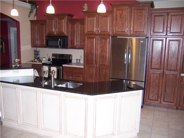 Red oak cabinets with a painted and glazed island - Raised panel doors - Standard overlay style - Granite countertop on the island with a stainless steel undermount sink